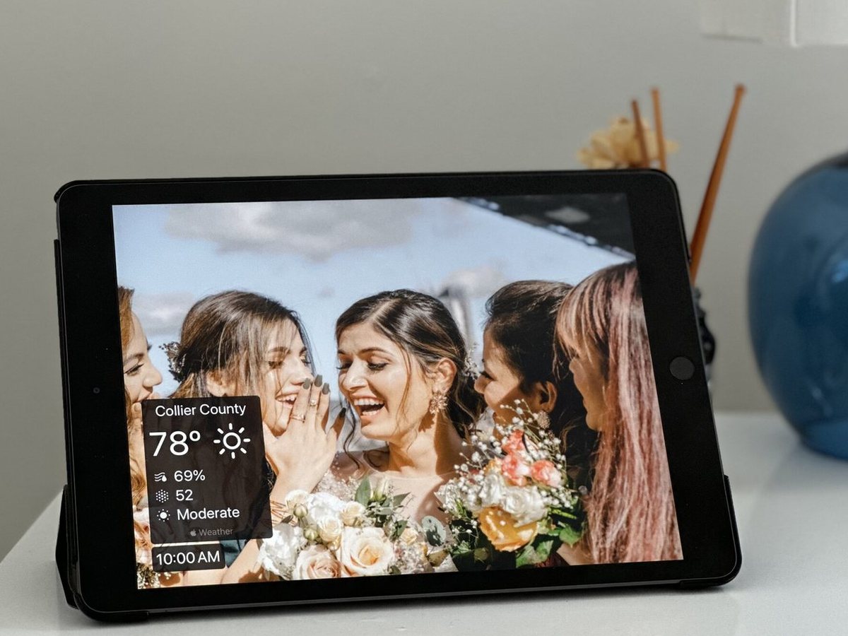 An iPad photo frame on a white dresser showing bridesmaids