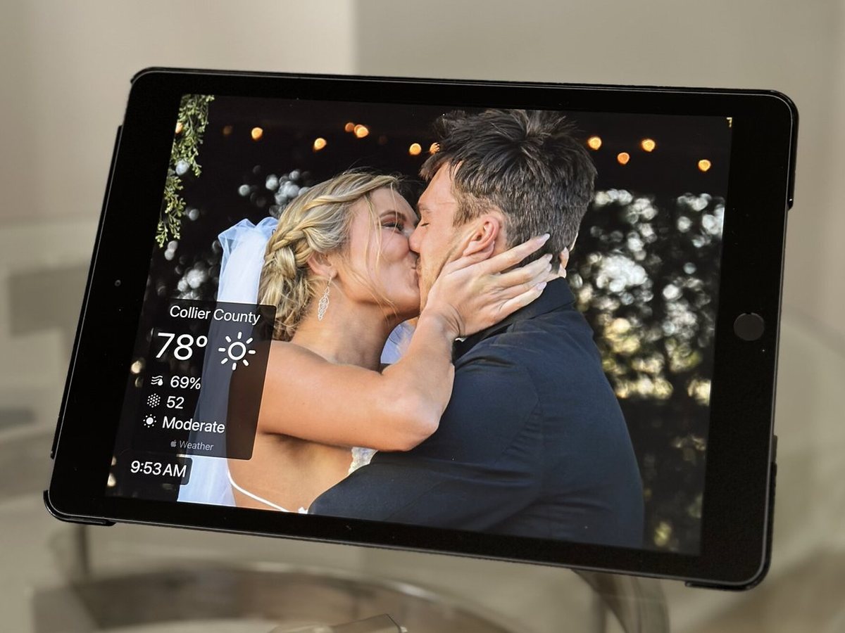 Un iPad como marco de fotos en una mesa de cristal con una foto de boda